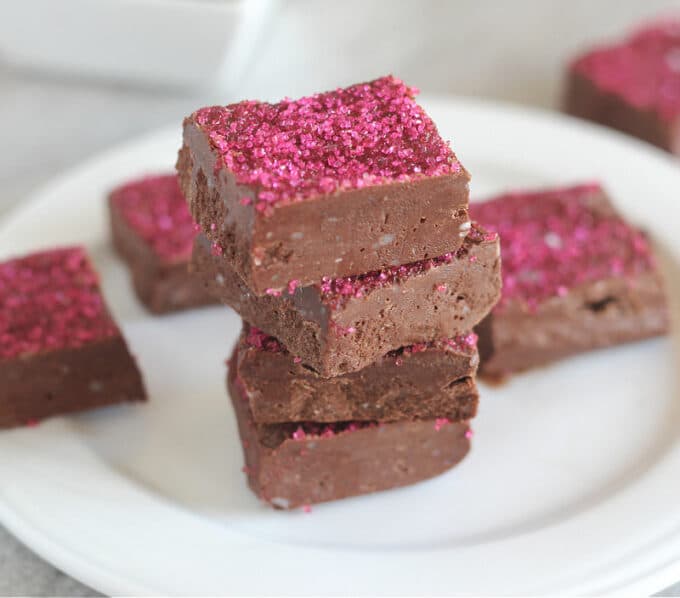 Stack of chocolate fudge with pink sprinkles on top.