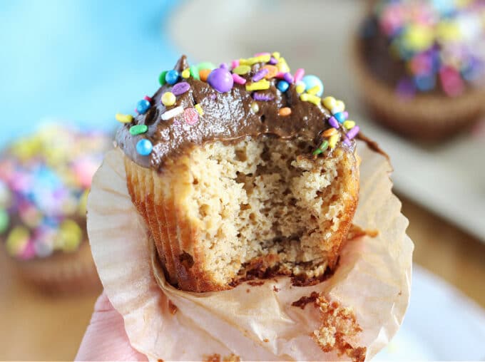 Vanilla cupcake with a bite out.