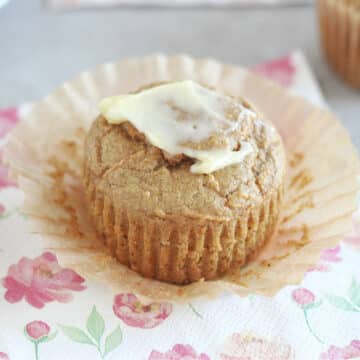 Muffin on a flower napkin with butter on top.