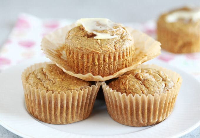 Stack of three muffin on a white plate.