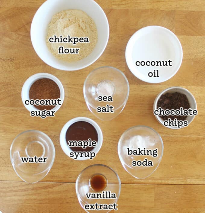 Ingredients laid out on a wood table, including chickpea flour and coconut oil.