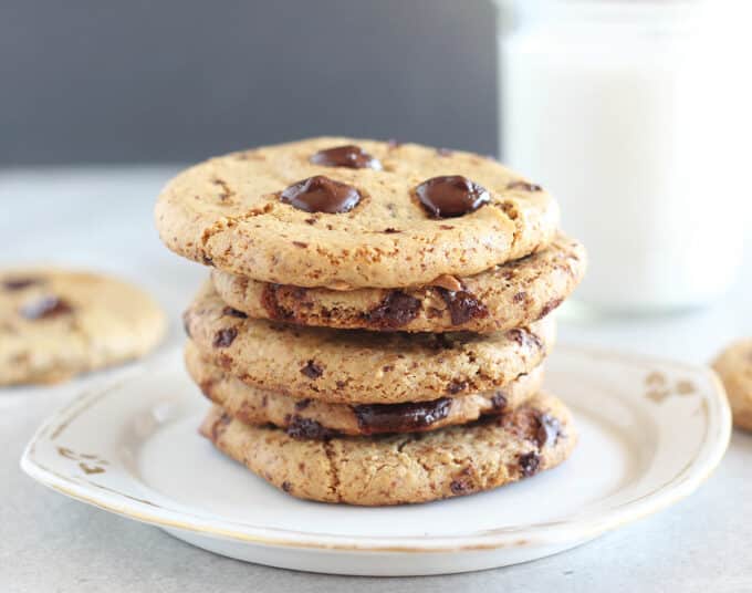Chocolate chip cookies stacked on a white plate.
