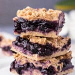 Stack of three blueberry bars on a plate.