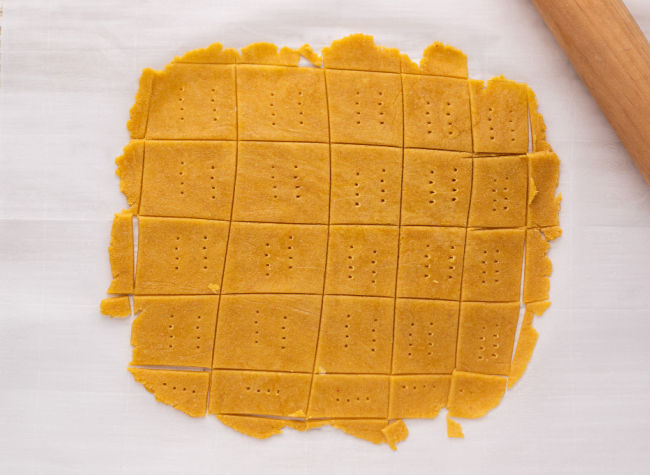 Unbaked crackers on a sheet.
