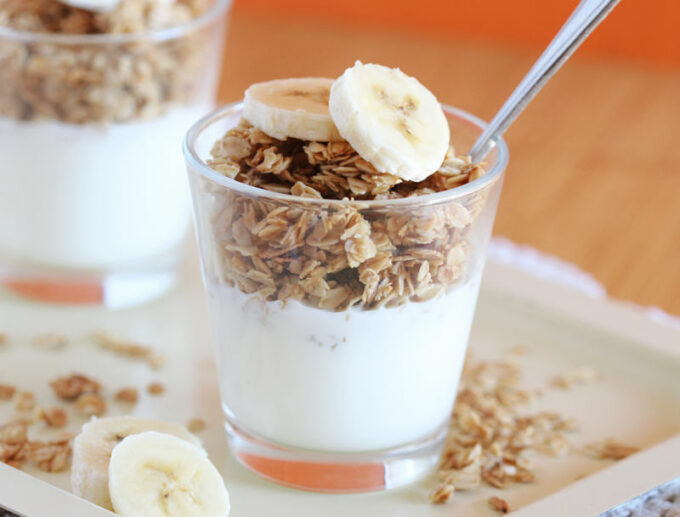 Parfait in a glass with bananas on top.