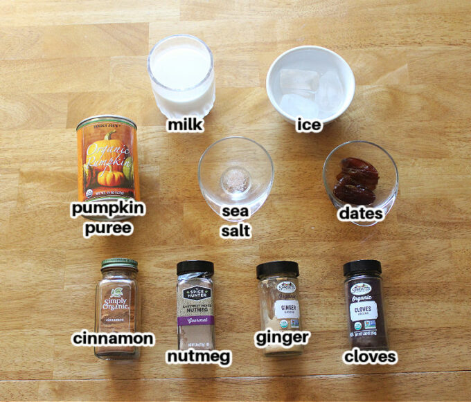 Smoothie ingredients laid out on a wood table, including a can of pumpkin.