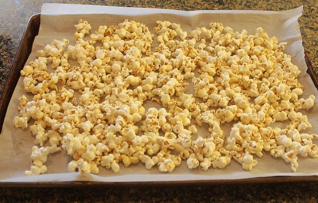 Popcorn spread out on a baking sheet.