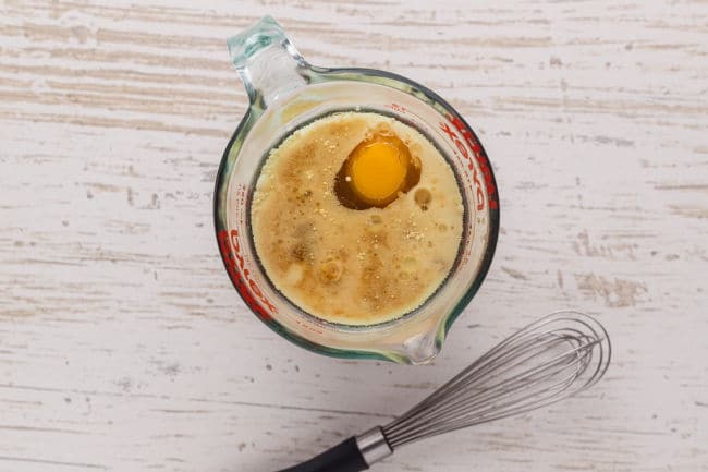 Egg, oil, and milk in a glass pitcher.