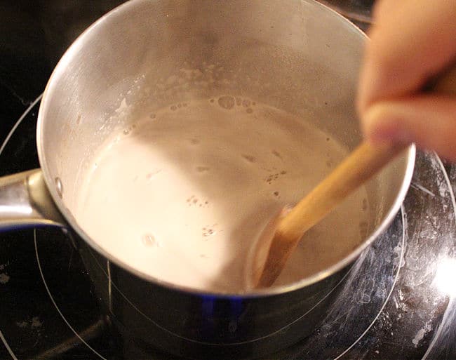 Stirring hot chocolate on a stove.