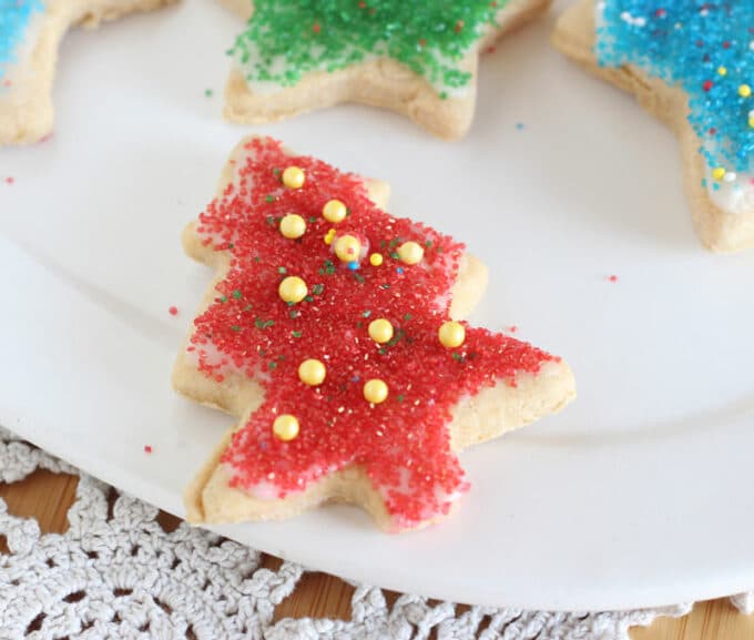 Christmas tree cookie decorated with red and yellow sprinkles.