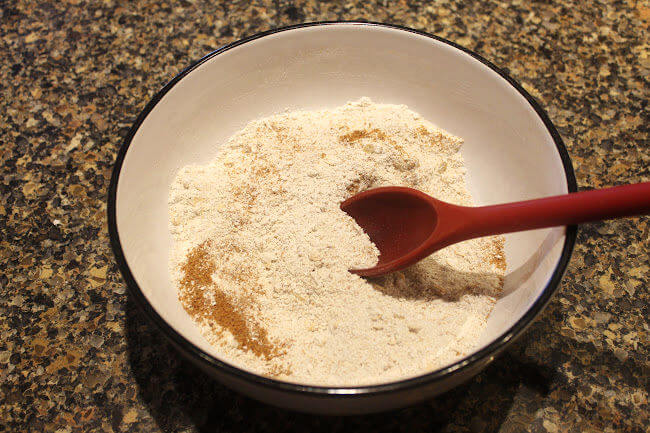 Stirring dry cookie ingredients in a bowl.