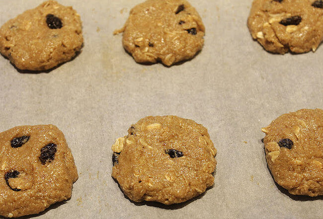 Raw oatmeal cookies on a baking sheet.