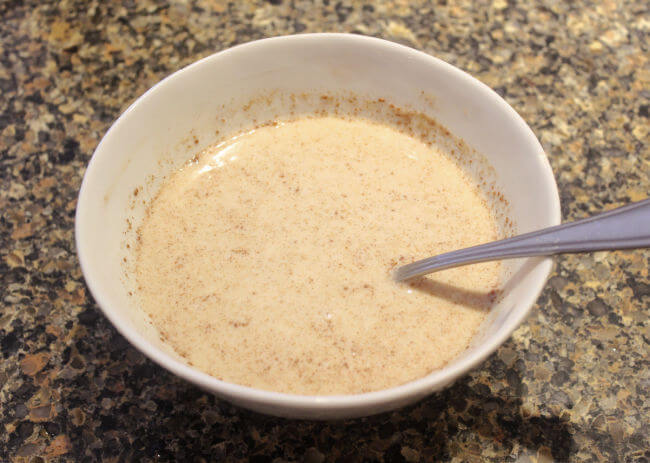 Overnight oats being stirred together in a bowl.