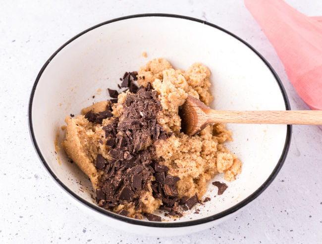 Stirring cookie dough with chocolate chips.