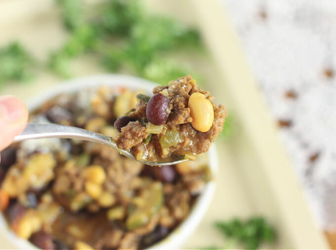 Spoonful of chili with white and black beans.