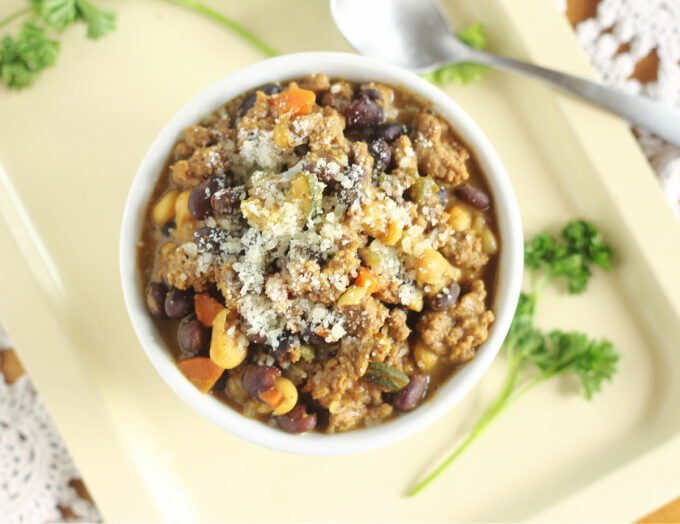 Top down view of a bowl of chili with parmesan on top.