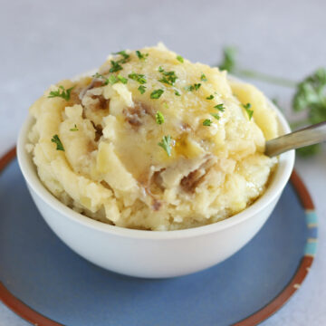 Mashed potatoes in a bowl on a blue plate.