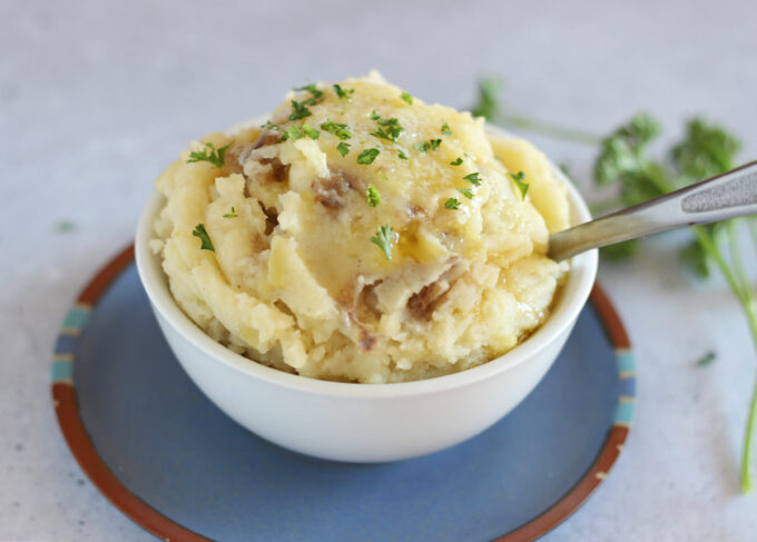 Mashed potatoes in a bowl on a blue plate.