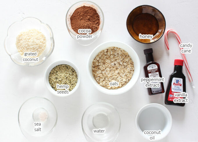 Various ingredients laid out on a table, including oats, hemp seeds, and cocoa powder.