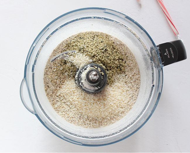 Oats, hemp, and coconut in a food processor.