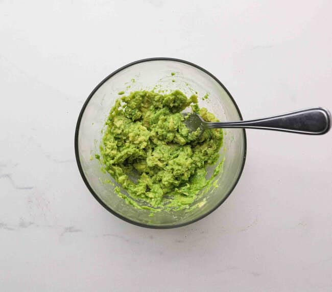 Mashing avocado in a bowl.