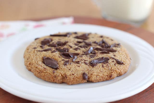 One chocolate chip cookie on a white plate.