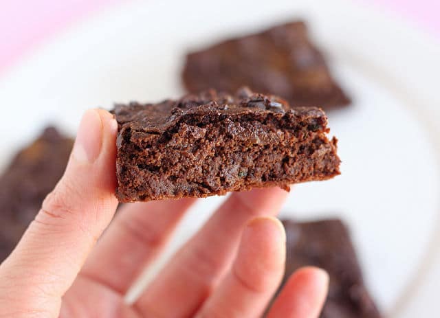 Hand holding a fudgy brownie.