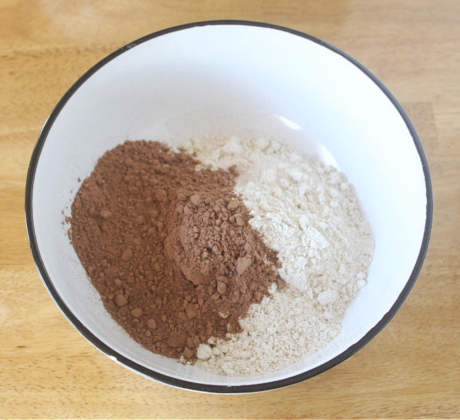 Oat flour and cocoa powder in a large white bowl.