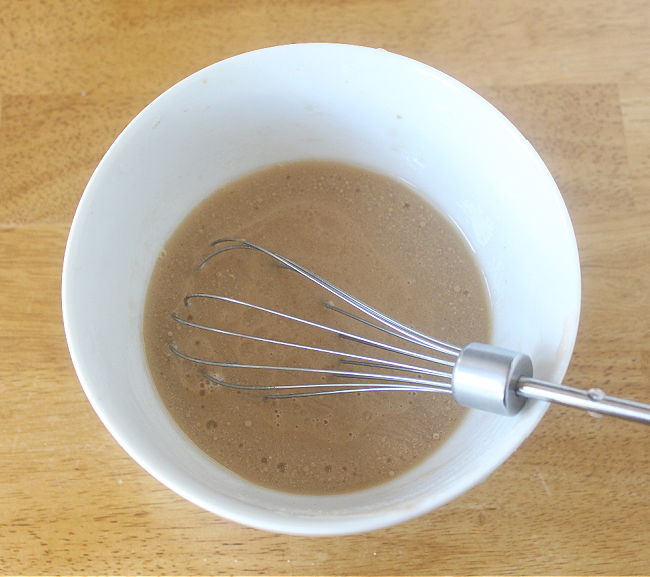 Whisking ingredients in a small white bowl.