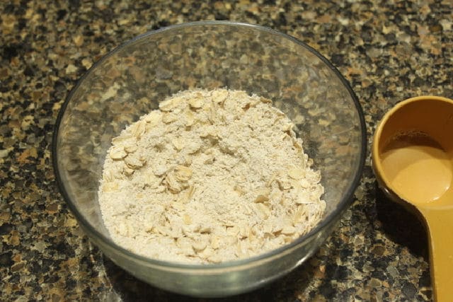 Oats and oat flour in a glass bowl.