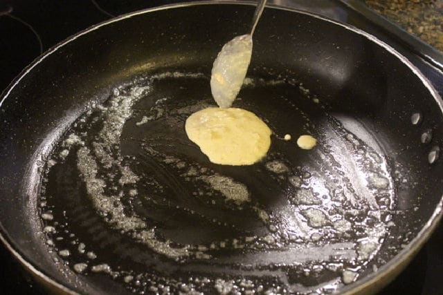 Pancake batter going into a skillet.