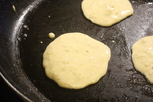 Oatmeal pancakes being cooked in a skillet.