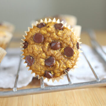 Pumpkin muffins with chocolate chips on a wire rack.