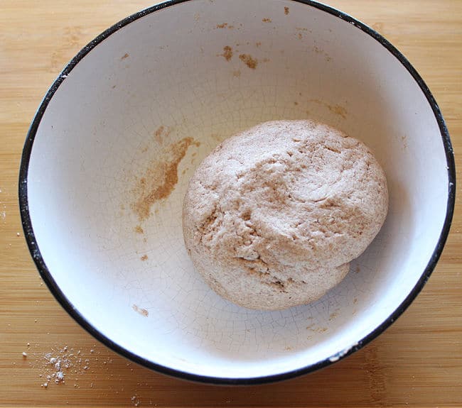 Ball of dough in a large white bowl.