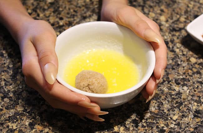 Ball of dough in a small bowl of melted butter.