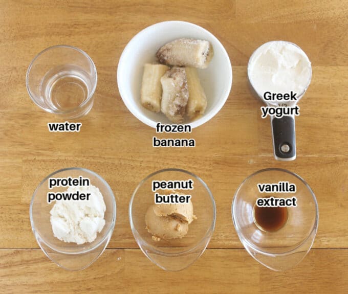 Ingredients laid out on a table, including banana, Greek yogurt, and peanut butter.