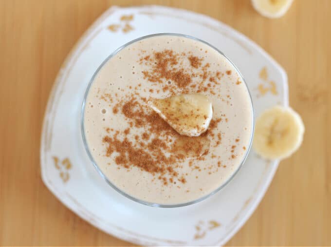 Top down view of smoothie with cinnamon and banana on top.