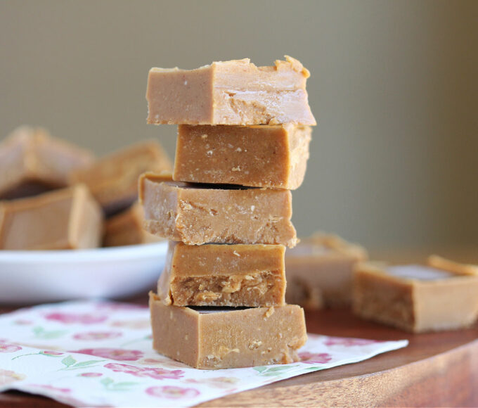 Stack of peanut butter fudge pieces on a flowered napkin.
