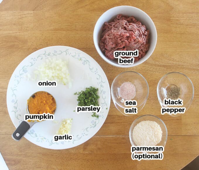 Various ingredients laid out on a table, including meat and pumpkin.