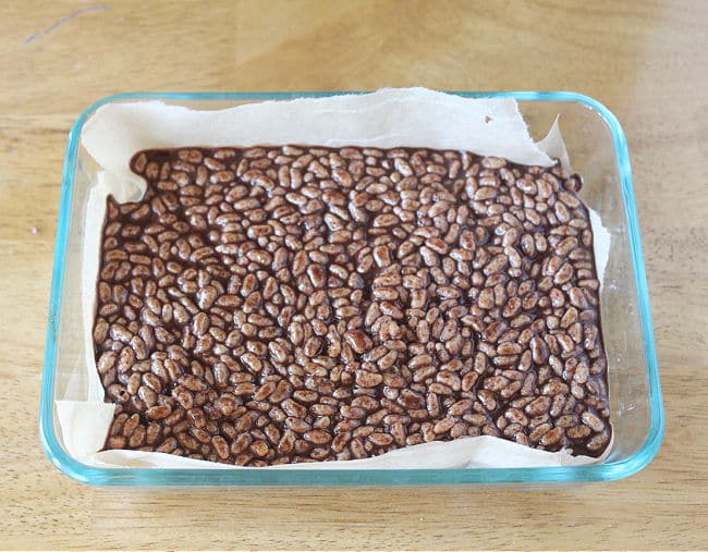 Melted chocolate and rice cereal in a small glass dish.