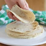 Hand holding a corn tortilla.