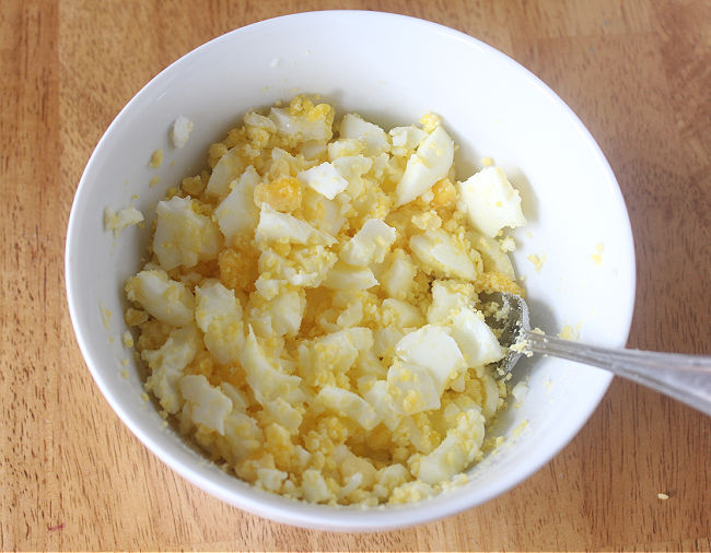 Mashed hard boiled eggs in a bowl.