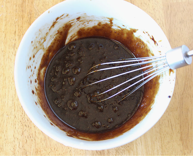 Whisking oil, sugar, and molasses.