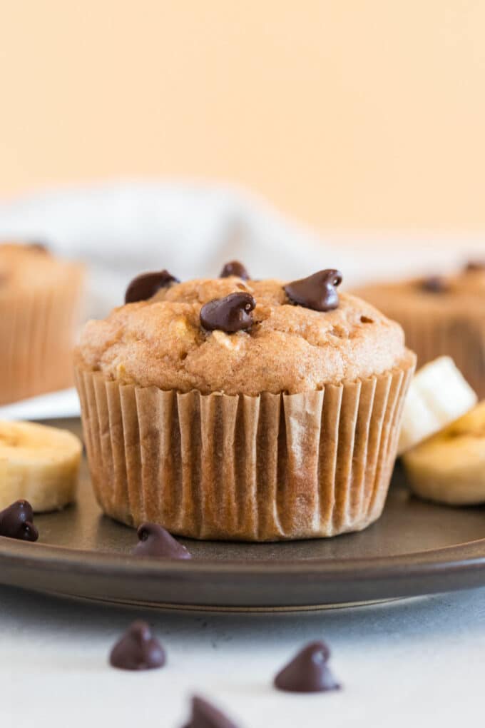Chocolate chip muffin on a dark plate.
