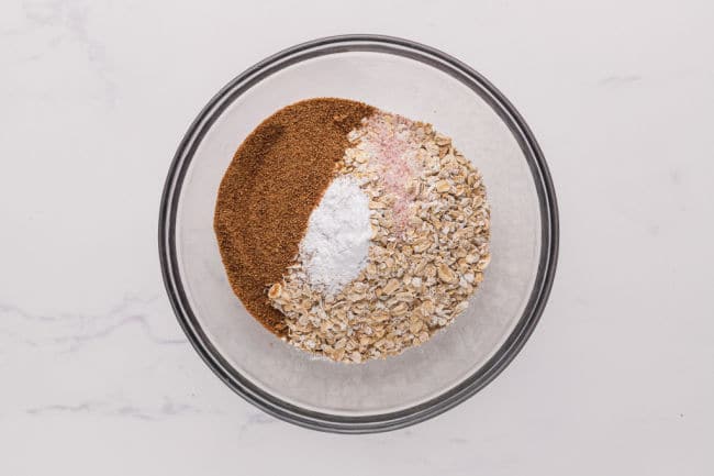 Flour, oats, sugar, and baking powder in a bowl.