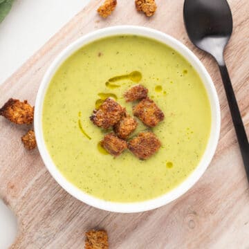 Green soup with croutons in a bowl.