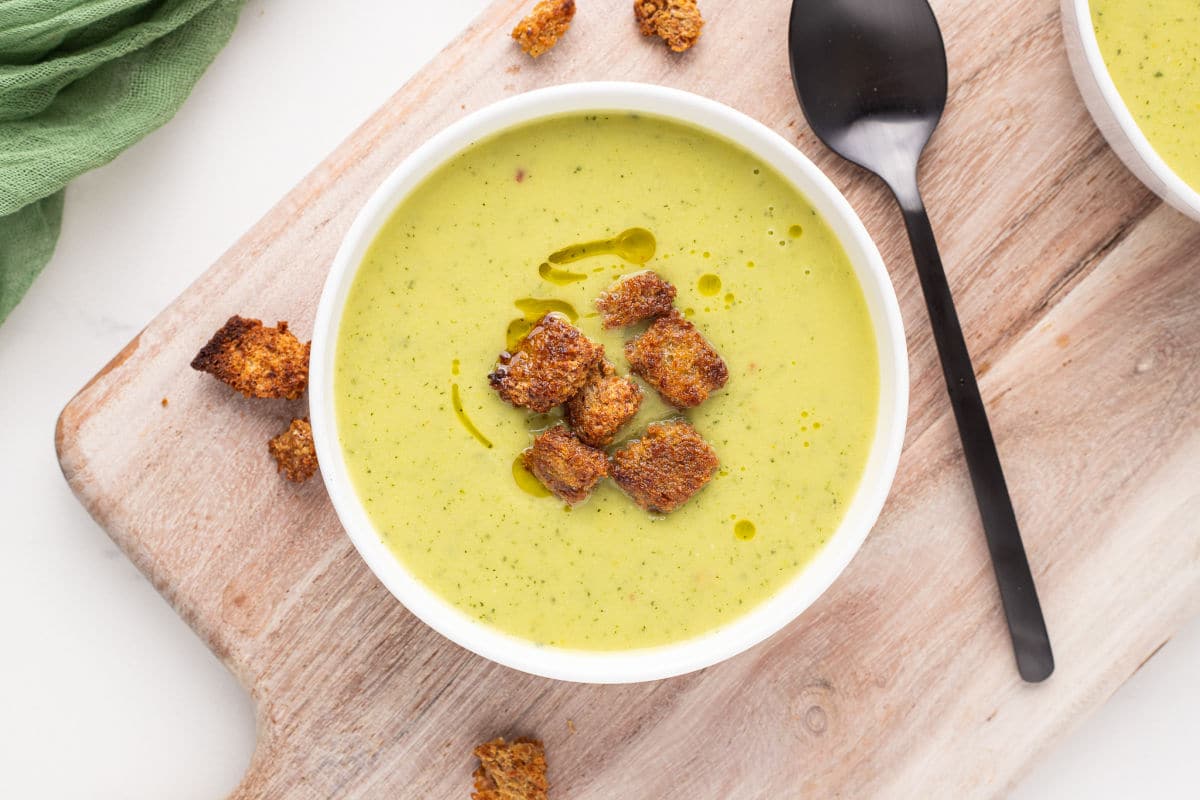 Green soup with croutons in a bowl.