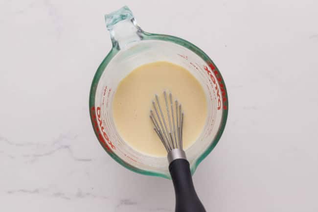 Whisking milk and egg in a measuring pitcher.