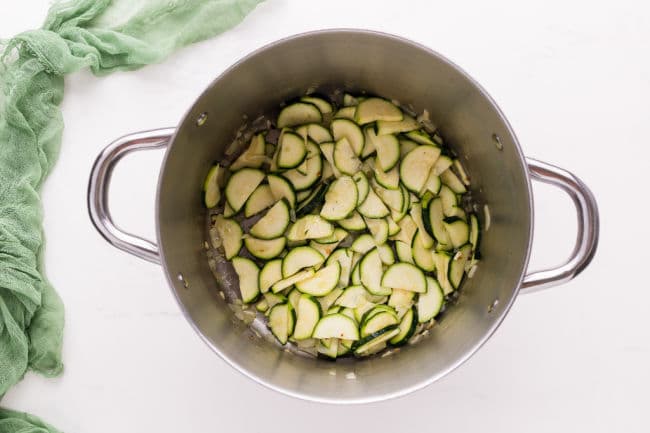 Raw zucchini slices in a large pot.
