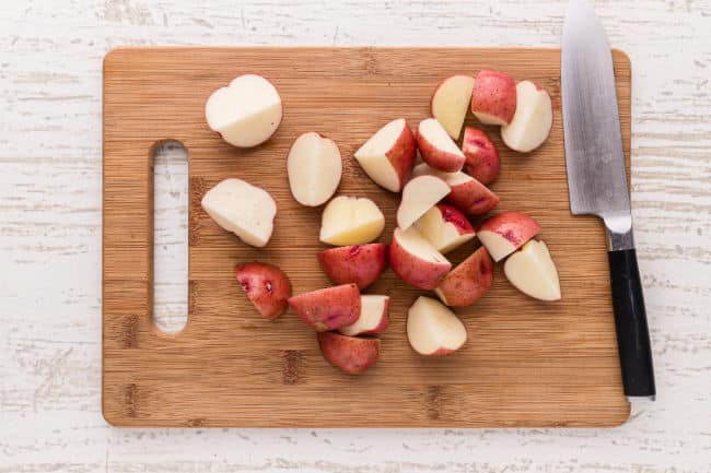 Chopped red potatoes on a cutting board.